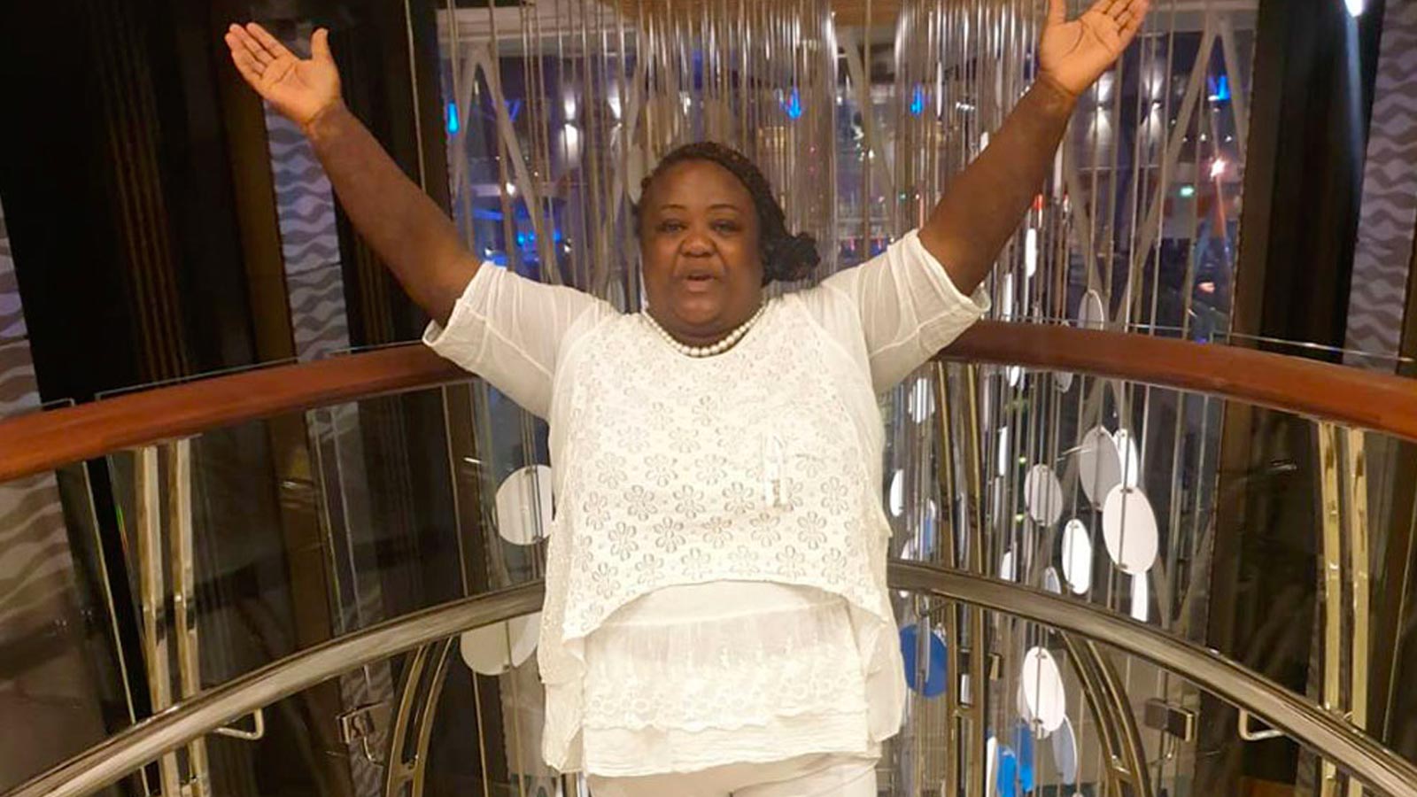 Zonia Anderson-Bell poses with her hands in the air